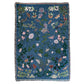 deep blue woven blanket with intricate moth and flower design and fringe