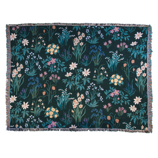 Spring flowers woven blanket in dark green with light coloured daffodils, forget me nots, primrose, anemones, lily of the valley, snowwdrops and  bluebells 