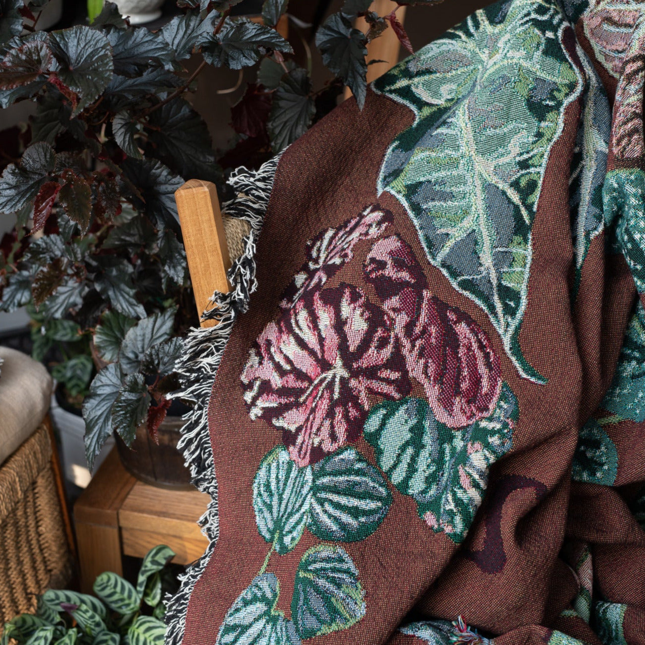 Woven throw blanket with fringe, featuring houseplants in stunning detail