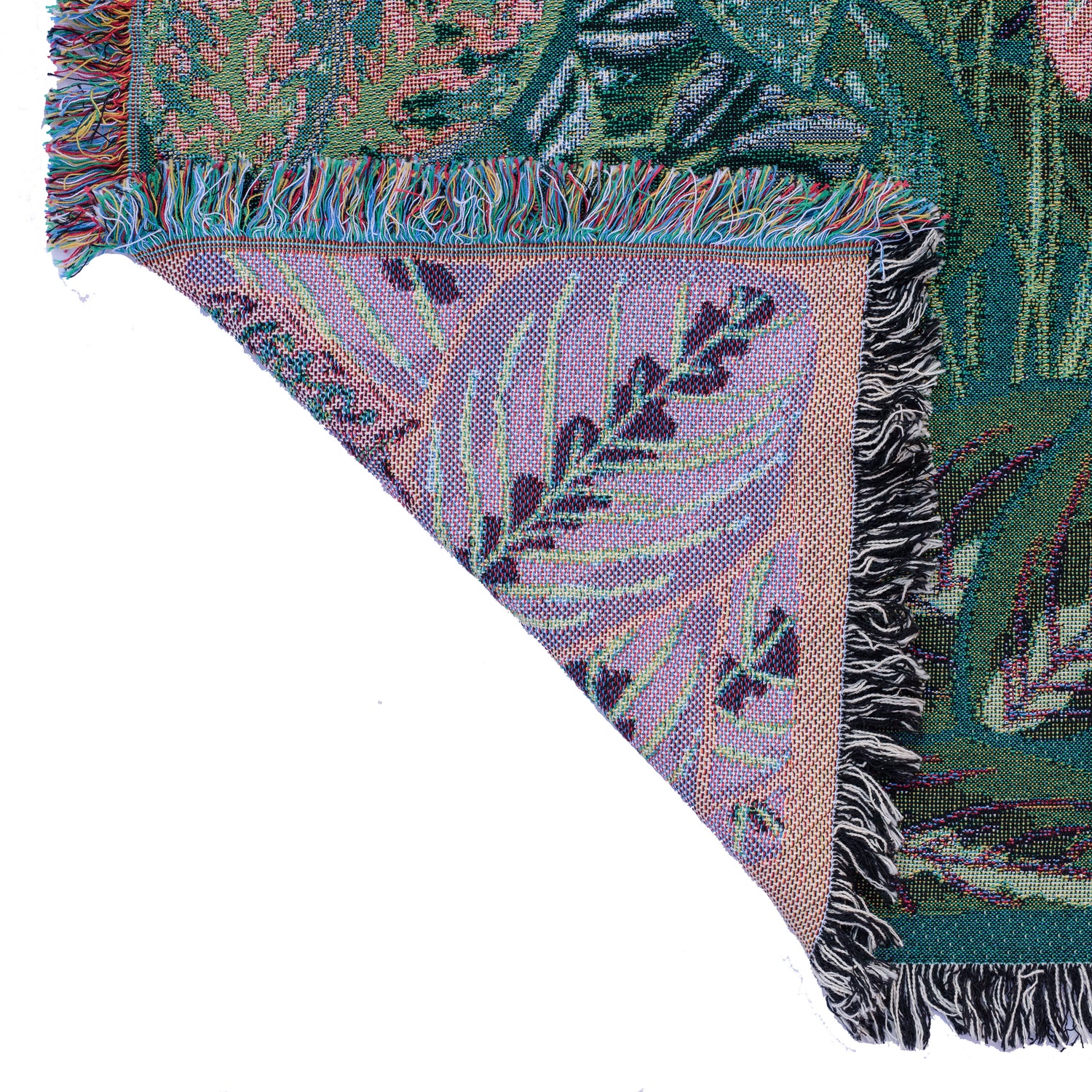 detail of woven wrap blanket with fringe featuring lots of different houseplants showing green front and purple back