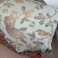 a bench with a Wild Oak Wrap Blanket by Arcana on it showing bird and squirrel pattern